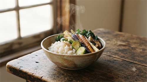 Cuenco de cerámica sencillo con arroz y vegetales sobre mesa de madera, luz natural suave, atmósfera serena y reverente