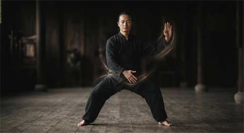 Practicante de artes marciales ejecutando una forma con los ojos cerrados en un entorno sereno