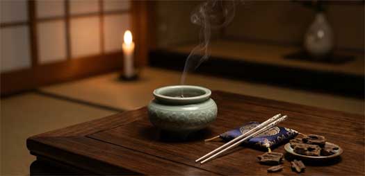 Utensilios tradicionales del Kōdō japonés sobre una mesa de madera, con un pequeño brasero y piezas de madera de agar