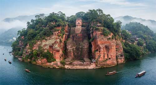 Vista frontal completa del Buda Gigante de Leshan tallado en el acantilado rojo, con los ríos Min y Dadu fluyendo serenamente a sus pies